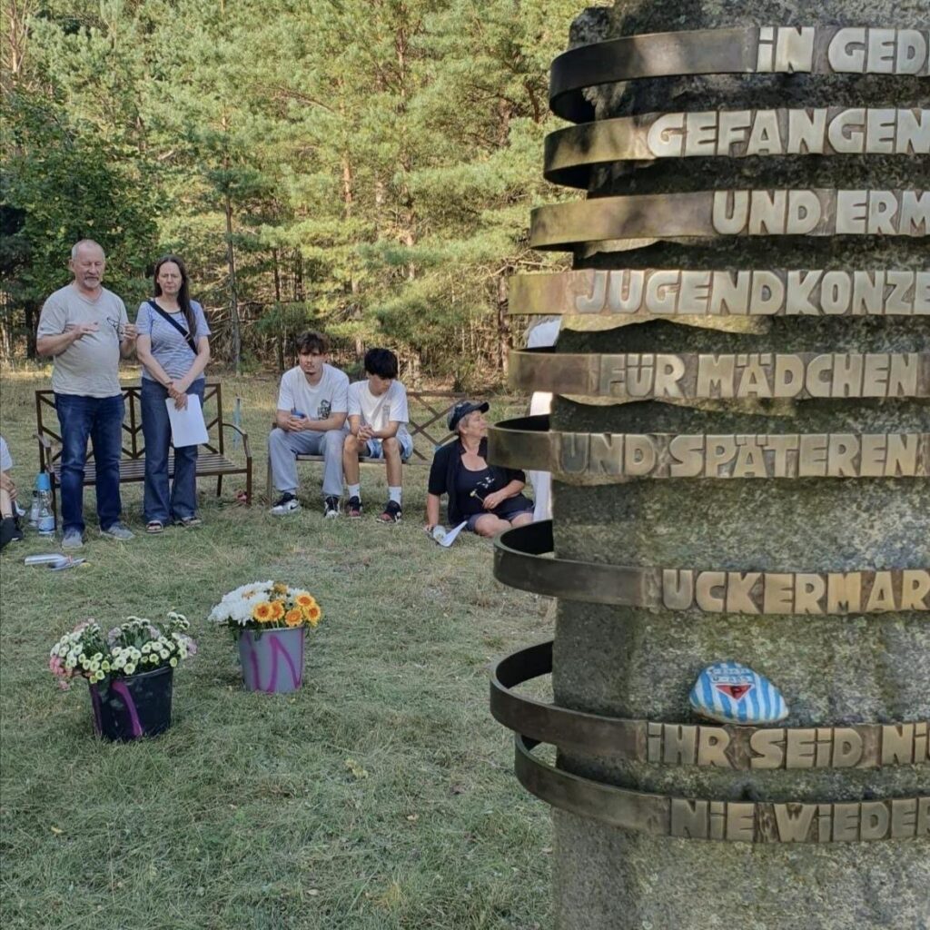 Marek Barwikowski steht am Gedenkstein auf dem Gedenkort Uckermark und spricht über die Erfahrungen seiner Mutter an diesem Ort